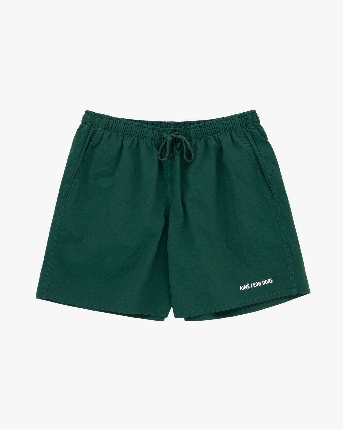 Logo Swim Short in dark green with side pockets and AIMÉ LEON DORE text on the left leg, shown on white background.