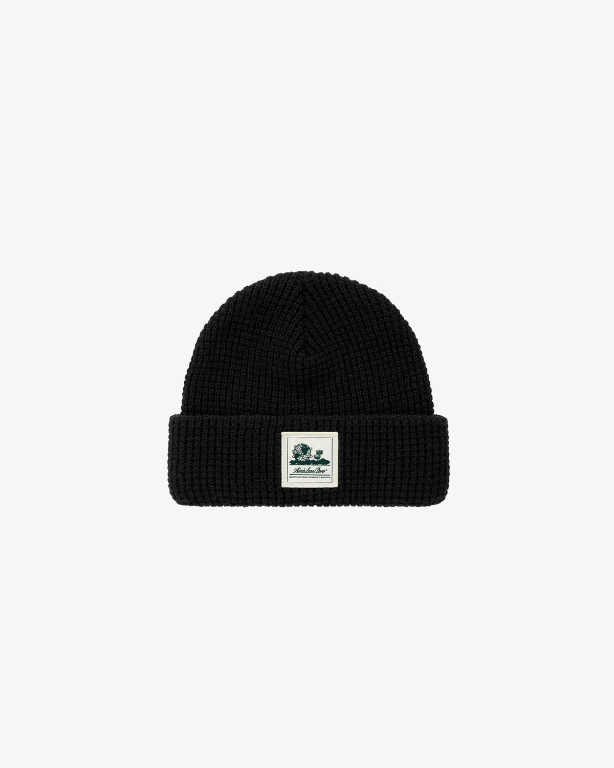 Waffle Knit Beanie in black with ribbed texture, folded brim, and white patch with green graphic and text.