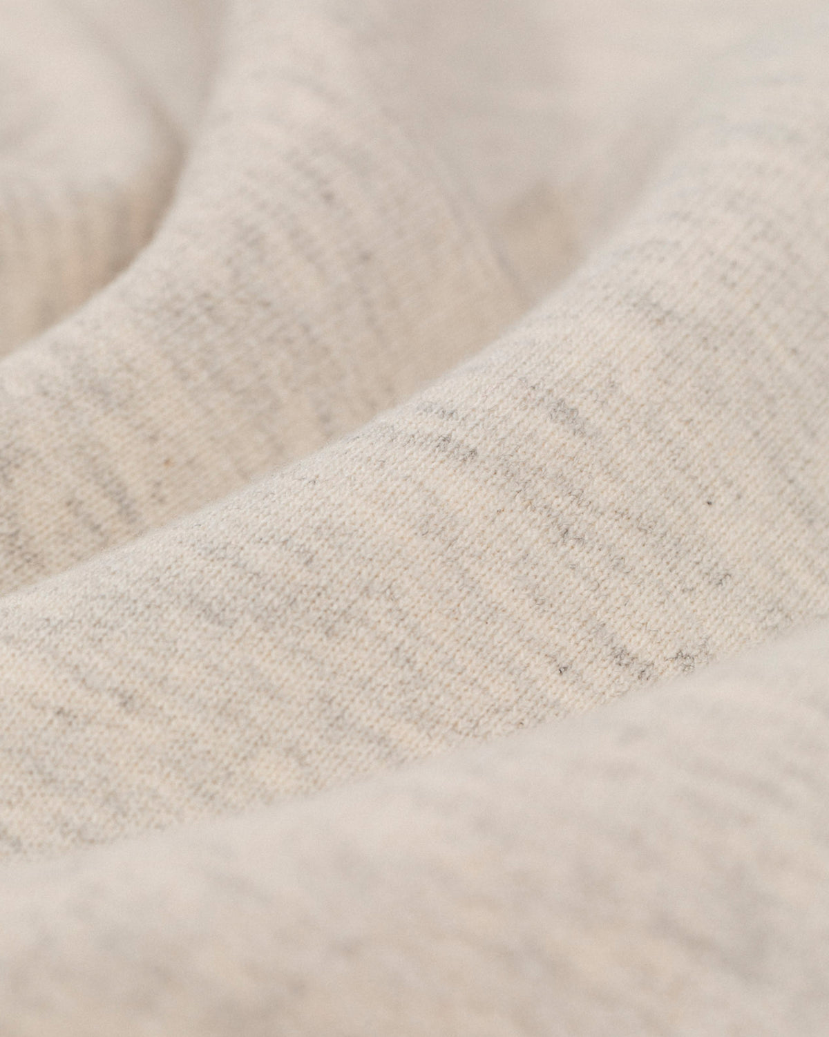 Close-up of Tonal Logo Sweatshorts in soft beige fabric with visible weave and gentle folds.